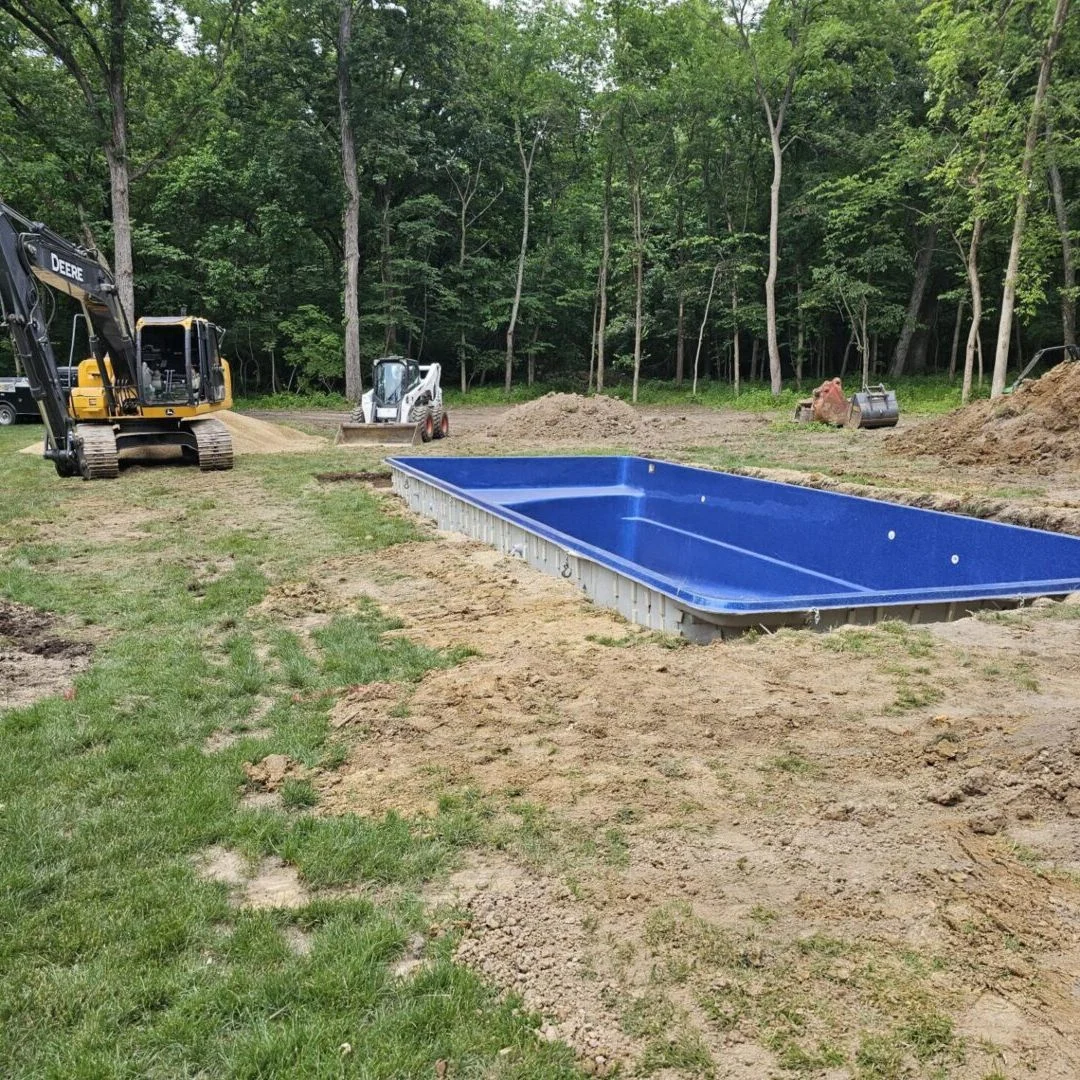 Pool shell being lowered into the ground